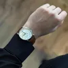 A person wearing a watch on their wrist. Voir les images du produit