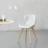 A white chair with wooden legs is shown in a room with a white textured wall and a grey floor. Anteprima dell’immagine prodotto