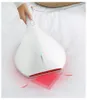 A hand holding a white vacuum cleaner over a white sheet. Produktbild-Vorschau