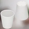 Two white ceramic pots with a textured surface are shown against a light gray and white background. One pot is upright and viewed from the side, while the other is inverted and viewed from the bottom. Podgląd zdjęcia produktu