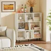 A white bookshelf filled with books and decorative items, placed in a living room setting next to a sofa and a rug. Podgląd zdjęcia produktu