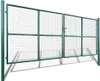 A green metal garden gate with mesh infill, shown in an outdoor setting with shadows. Náhled obrázku produktu