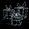 Three illuminated gift boxes with bows on a black background. Podgląd zdjęcia produktu