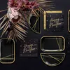 A flat lay arrangement of black and gold New Year's themed party supplies, including plates and napkins, with decorative foliage. Produktbild-Vorschau