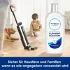 A person is using a Tineco floor cleaner while a child and a dog are in the background. A bottle of Tineco cleaning solution is also visible. Produktbild-Vorschau