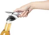 A hand is using a bottle opener to open a bottle of beer. Podgląd zdjęcia produktu