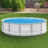 An above-ground swimming pool covered with a solar blanket, set up on a grassy lawn in a backyard. Podgląd zdjęcia produktu