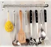 A set of kitchen utensils hanging on a wall rack. Produktbild-Vorschau