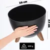 A hand is holding a black planter with wooden legs. Dimensions and weight are indicated. Náhled obrázku produktu