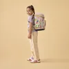 A young girl wearing a backpack and looking over her shoulder. Voir les images du produit