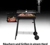 A black charcoal grill with a side firebox, cooking meat and emitting smoke, set against a gradient background. Produktbild-Vorschau