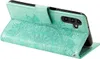 A teal flip case for a smartphone, with a mandala embossed design, is shown from a side angle. Produktbild-Vorschau