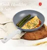 A frying pan with food inside, placed on a cloth and a wooden board. Podgląd zdjęcia produktu