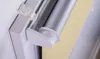 A close-up view of a white roller blind mechanism attached to a window frame. Produktbild-Vorschau