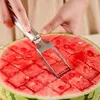 A person is using a stainless steel watermelon slicer to cut a watermelon into cubes. Produktbild-Vorschau
