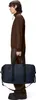 A person is shown from the side, holding a duffel bag. Produktbild-Vorschau