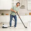 A man is using a steam cleaner in a kitchen. Produktbild-Vorschau