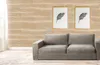 A living room scene with a sofa against a wood-paneled wall and two framed feather prints. Anteprima dell’immagine prodotto