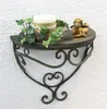 A wall shelf with a candle, ivy, and an angel figurine. Produktbild-Vorschau