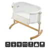 A white baby bassinet with a wooden rocking base, shown from a slightly elevated side angle against a white background. Produktbild-Vorschau