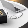 A laptop is connected to a speaker with an audio cable. Produktbild-Vorschau