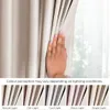 A hand is shown touching a light beige curtain, with a series of smaller images below demonstrating how the color of the curtain appears under different lighting conditions. Produktbild-Vorschau