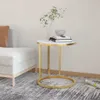 A round side table with a marble-look top and gold metal frame, placed next to a sofa in a living room setting. Náhľad obrázku produktu