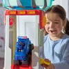 A young girl plays with a Paw Patrol Tower HQ toy, interacting with a blue Paw Patrol vehicle. Náhľad obrázku produktu