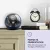A watch winder and an alarm clock are displayed on a shelf, with text overlay providing product information. Produktbild-Vorschau