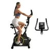 A woman is using a stationary exercise bike. Produktbild-Vorschau