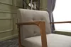 Close-up of a cream-colored armchair with wooden armrests. Produktbild-Vorschau