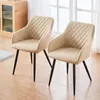 Two beige upholstered chairs with diamond stitching and black legs are shown in a room with wooden flooring and a window in the background. Produktbild-Vorschau