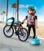 A Playmobil figure of a cyclist with his bicycle on a beach path, with palm trees and the ocean in the background. Anteprima dell’immagine prodotto