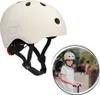 A cream-colored helmet is shown on the left, and a boy wearing a similar helmet is shown riding a scooter on the right, within a circular frame. Náhled obrázku produktu