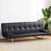 A black faux leather sofa bed is shown in a room with a plant and a patterned rug. Produktbild-Vorschau