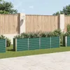 A row of green metal raised garden beds filled with plants, set against a wooden fence and a paved patio. Podgląd zdjęcia produktu
