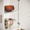 Interior view of a white cabinet with kitchenware on shelves. Náhľad obrázku produktu