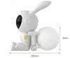 A white robot with bunny ears and a large white ball attached to its back, sitting down. Dimensions are indicated. Náhled obrázku produktu