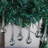 Several glass icicle ornaments hang from a green artificial Christmas tree. Produktbild-Vorschau
