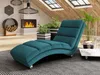 A teal chaise lounge is placed in a modern living room with a fireplace and skylights. Náhled obrázku produktu