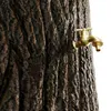 A close-up of a tree trunk with a brass faucet attached. Produktbild-Vorschau