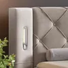 A close-up view of a bed's headboard and side panel, featuring a built-in light. Produktbild-Vorschau