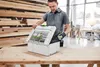 A man is opening a tool case in a workshop. Voir les images du produit