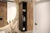 A modern bathroom vanity with a round mirror and a wall-mounted cabinet. Produktbild-Vorschau