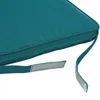 A close-up view of a teal cushion with attached straps and velcro fasteners. Produktbild-Vorschau