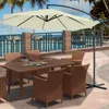 An outdoor patio scene with a table and chairs set up under a large cantilever umbrella, next to a swimming pool. Voir les images du produit