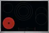 A top-down view of a black glass ceramic hob with four cooking zones, one of which is glowing red. Podgląd zdjęcia produktu