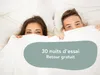 Couple peeking from under a duvet in bed with a promotional overlay. Voir les images du produit