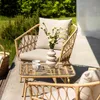 An outdoor patio setting with wicker furniture and flowers. Náhled obrázku produktu