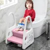 A young child is using a potty training step stool next to a toilet. Voir les images du produit